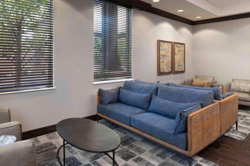 a living room with a blue couch and a table at Hampton Inn Lewiston-Auburn in Lewiston