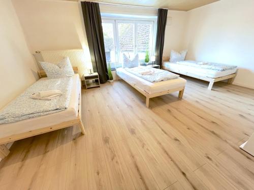 a bedroom with two beds and a large window at III Apartment für bis zu 6 Personen, 94431 Großköllnbach in Pilsting
