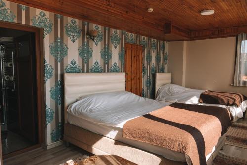 two beds in a bedroom with wallpaper at Green Life Apart Hotel in Istanbul