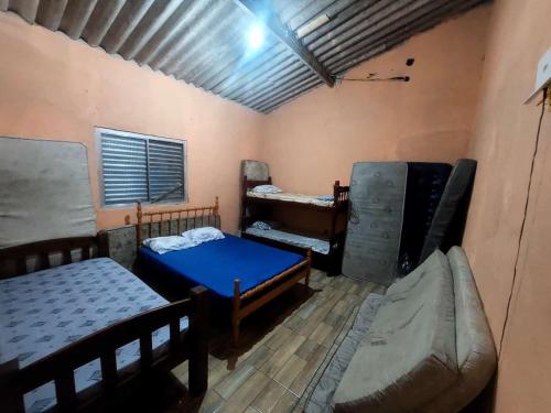 a room with two beds and a couch in it at Casa da rafaa in Itanhaém