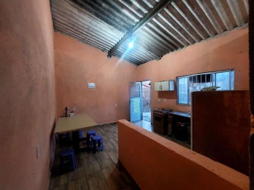 a room with a kitchen with a counter and a table at Casa da rafaa in Itanhaém