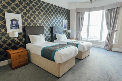 a hotel room with two beds and a window at Queens Hotel & Spa in Brighton & Hove