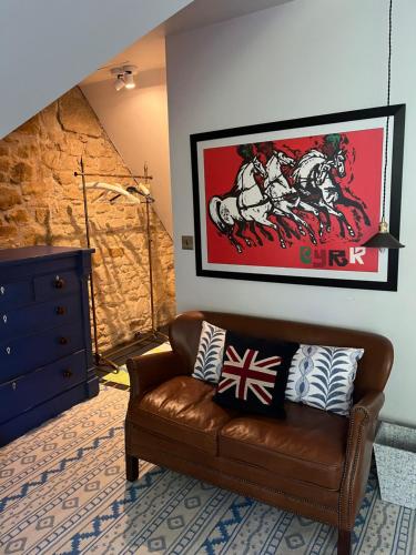 a living room with a brown leather couch with pillows at Eskbank Villa near Edinburgh in Dalkeith