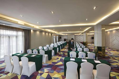 a room with rows of chairs and a man standing in the middle at Wyndham Garden Suzhou in Suzhou