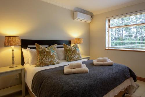 a bedroom with a bed with two towels on it at Raptor Rise Farm in Tulbagh