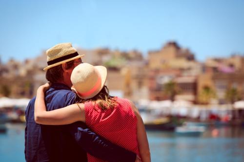 a man and woman hugging each other near the water at Authentic Maltese Boutique Holiday Home with Rooftop Pool - Moon Townhouse in Cospicua