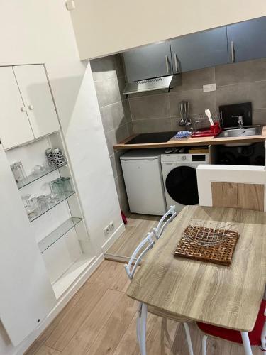 une petite cuisine avec une table et un évier dans l'établissement Charmant F2 de 35 m2 idéalement situé à Épinay-sur-Seine, à Épinay-sur-Seine