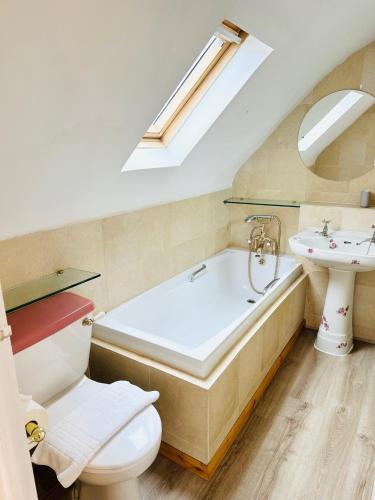 a bathroom with a tub and a sink and a toilet at Oxford Grade II listed house in Woodstock