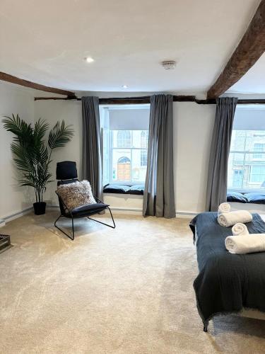 a bedroom with two beds and a chair and a window at Oxford Grade II listed house in Woodstock