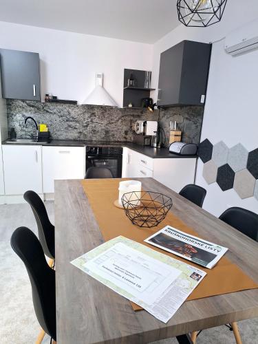 a kitchen with a wooden table and black chairs at apartmán Argentum - Rezidence K Lanovce in Jáchymov
