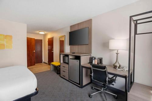 a hotel room with a bed and a desk with a computer at Comfort Inn & Suites Harrisburg-Hershey North in Harrisburg