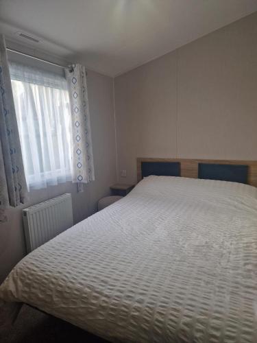a bedroom with a white bed and a window at Cresswell Towers in Morpeth