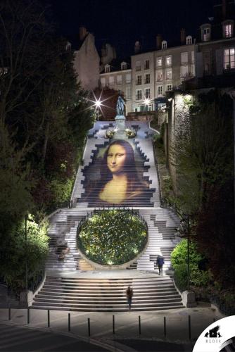 a large statue of a woman on a staircase at night at COEUR DE BLOIS CHARMANT APPART LOUIS XII VUE LOIRE in Blois