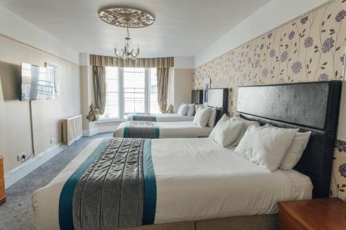a hotel room with three large beds in it at Queens Hotel & Spa in Brighton & Hove