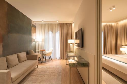 a hotel room with a couch and a bed at Bellerive Lifestyle Hotel in Salò