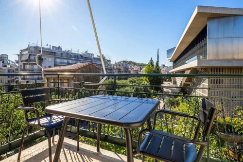 a table and chairs on the balcony of a building at Modern Apt opposite the Acropolis Museum in Athens