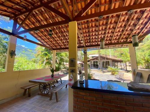 an outdoor patio with a table and a pool at Chalé e Cachoeira Sítio Igrejinha Serra da Bocaina in Bananal