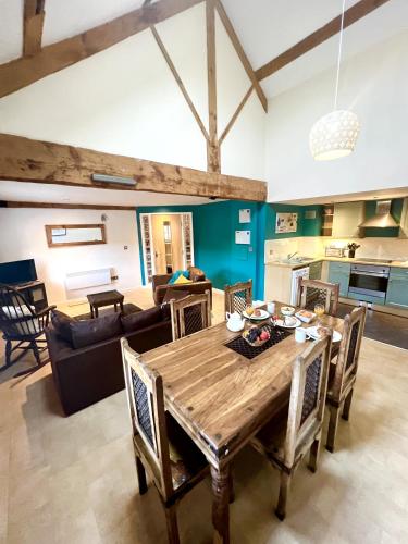 a dining room and living room with a wooden table at Grand Mill: Near to Shops, Attractions, Restaurant in Burton upon Trent