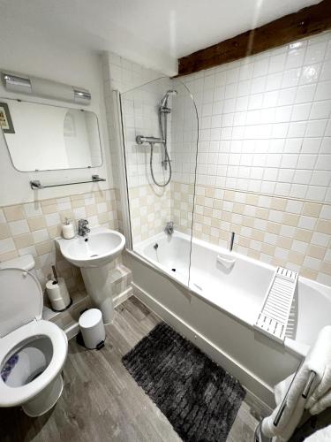 a bathroom with a toilet and a tub and a sink at Grand Mill: Near to Shops, Attractions, Restaurant in Burton upon Trent