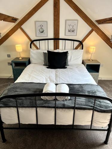 a bedroom with a large bed with two night stands at Grand Mill: Near to Shops, Attractions, Restaurant in Burton upon Trent