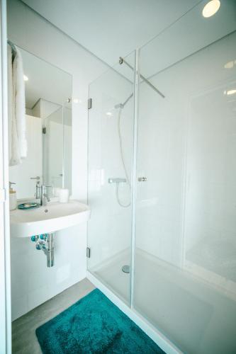 a white bathroom with a shower and a sink at Casa do Marujo e Casa do Mirone in Fornos de Algodres