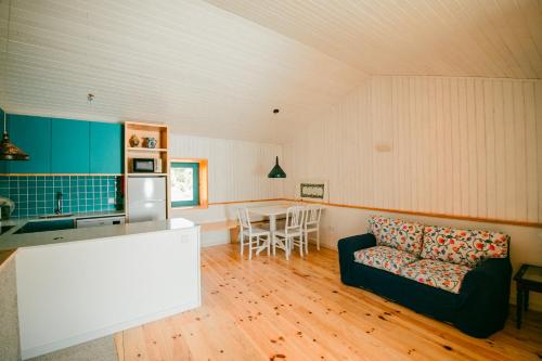 a kitchen and living room with a couch and a table at Casa do Marujo e Casa do Mirone in Fornos de Algodres