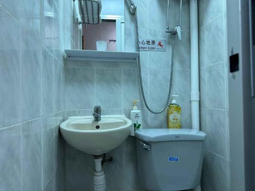 a small bathroom with a sink and a toilet at Good Fortune Inn in Hong Kong