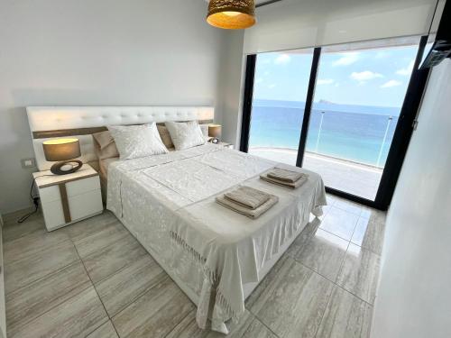 a bedroom with a bed with a view of the ocean at Exclusive Apartments on the first line of Benidorm Mar y Sol in Benidorm