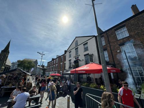a crowd of people walking down a city street at Y Castell in Caernarfon