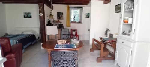 un salon avec une table et un lit dans l'établissement Les Grandes Oreilles, à Vierzon