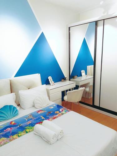 Un dormitorio con dos camas y una pared azul. en Maya Bay Residences SplashMania, en Banting