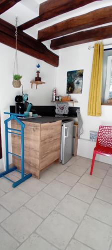une cuisine avec une table bleue et une chaise rouge dans l'établissement Les Grandes Oreilles, à Vierzon