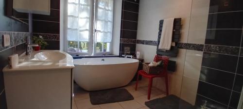 une salle de bain avec une baignoire, un lavabo et une fenêtre dans l'établissement Les Grandes Oreilles, à Vierzon