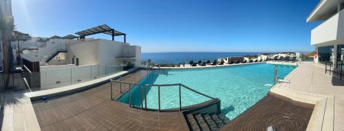 a large swimming pool with the ocean in the background at El Mirador Casa #8 in Torrox Costa