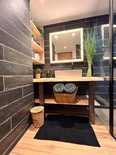 une salle de bain avec un lavabo et un miroir dans l'établissement Appartement face à l'océan Chez Tao, à Capbreton