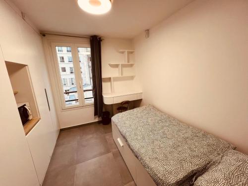 une petite chambre avec un lit et une fenêtre dans l'établissement Charming Studio near Châtelet Saint Sauveur, à Paris