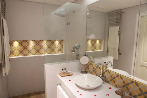 a bathroom with a sink and a mirror at Herdade Do Sobroso Wine & Luxury Boutique Hotel in Pedrógão