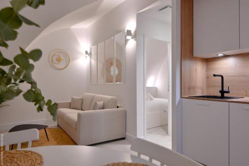 - un salon blanc avec un canapé et une chaise dans l'établissement Ancienne cave de pêcheur, à La Ciotat