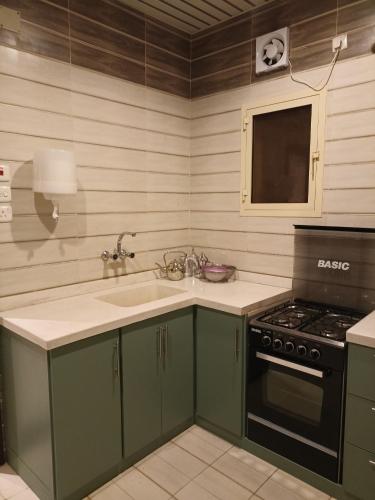 a kitchen with a sink and a stove at رغيد للشقق الفندقية حائل - طريق جرير in Hail