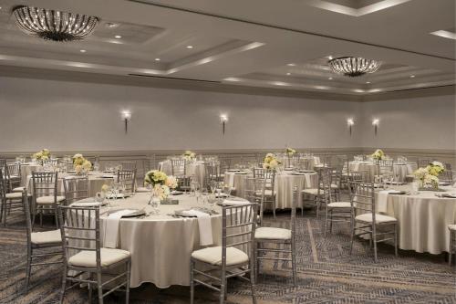 a banquet room with tables and chairs with white tablecloths at Bakersfield Marriott at the Convention Center in Bakersfield