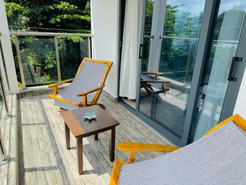 a room with two chairs and a table and windows at Bijoutier Apartments in Grand'Anse Praslin