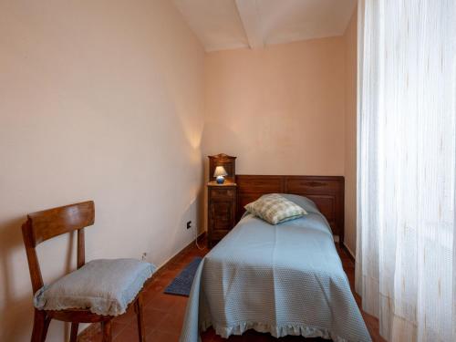 a small bedroom with a bed and a chair at Apartment Casa dei Nonni by Interhome in Cascine di Pietra