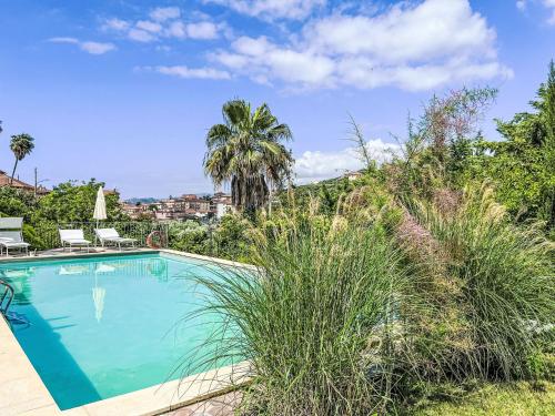 una piscina en una villa con palmeras en Apartment Il Risveglio-6 by Interhome, en Imperia
