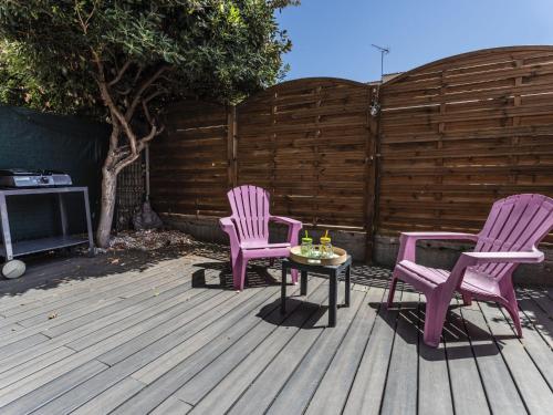 2 chaises roses et une table sur une terrasse dans l'établissement Apartment Les Grenadines-2 by Interhome, au Cap d'Agde