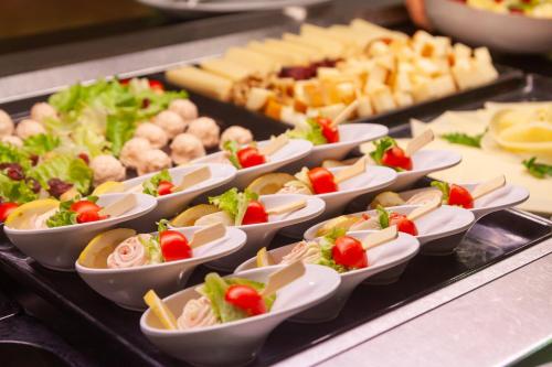 a bunch of appetizers in small dishes on a buffet at Hotel Toplice - Terme Krka in Smarjeske Toplice