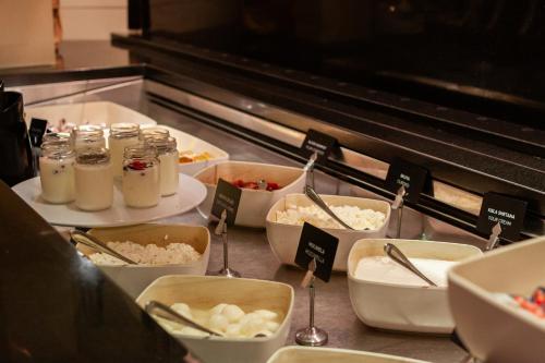a buffet line with bowls of food on a counter at Hotel Toplice - Terme Krka in Smarjeske Toplice