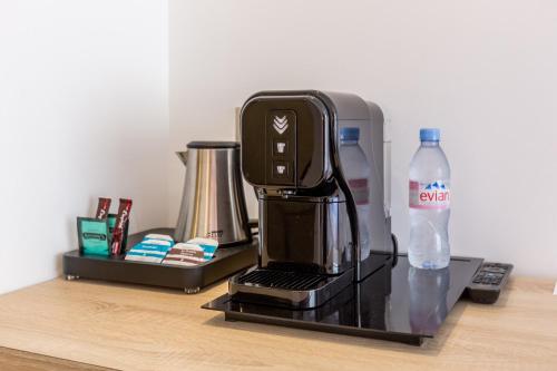 a coffee maker on a counter with a bottle of water at Hôtel De Castiglione in Paris