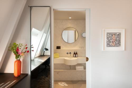 a bathroom with a sink and a mirror at Maison ELLE Amsterdam in Amsterdam