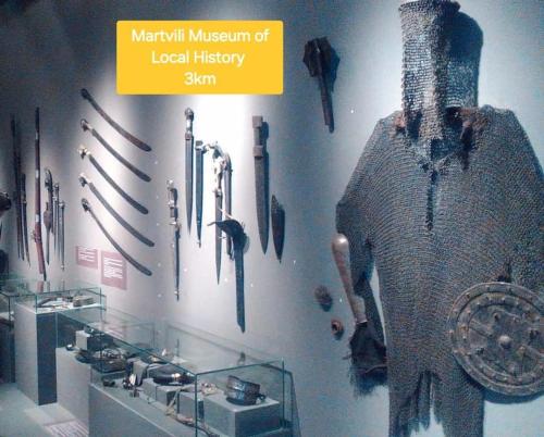 a museum display of medieval weapons on a wall at BaBa guesthouse in Martvili