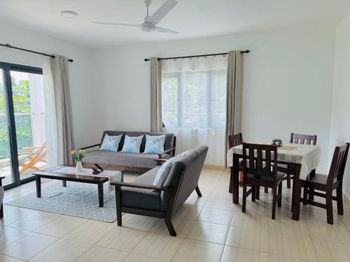 a living room with a couch and a table at Bijoutier Apartments in Grand'Anse Praslin